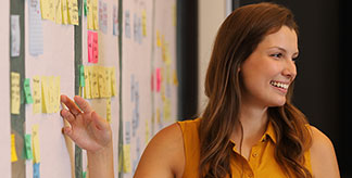 A woman speaking in front of a project plan