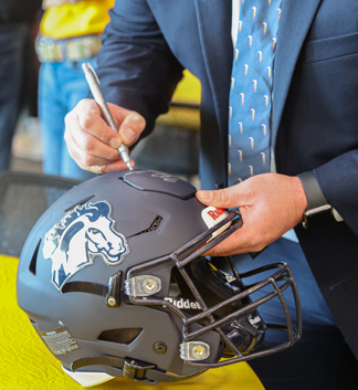 coach md daniels signing football helmet
